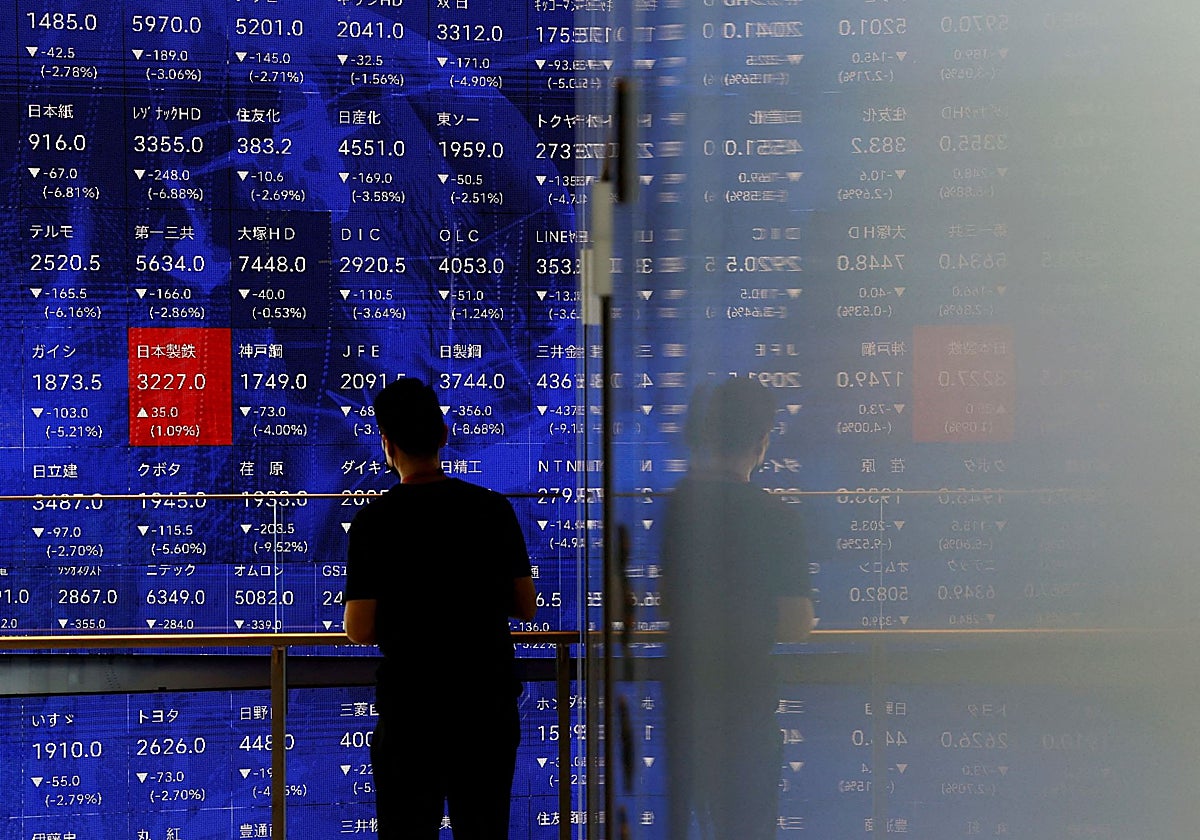 Un hombre mira las cotizaciones en Tokio, Japón