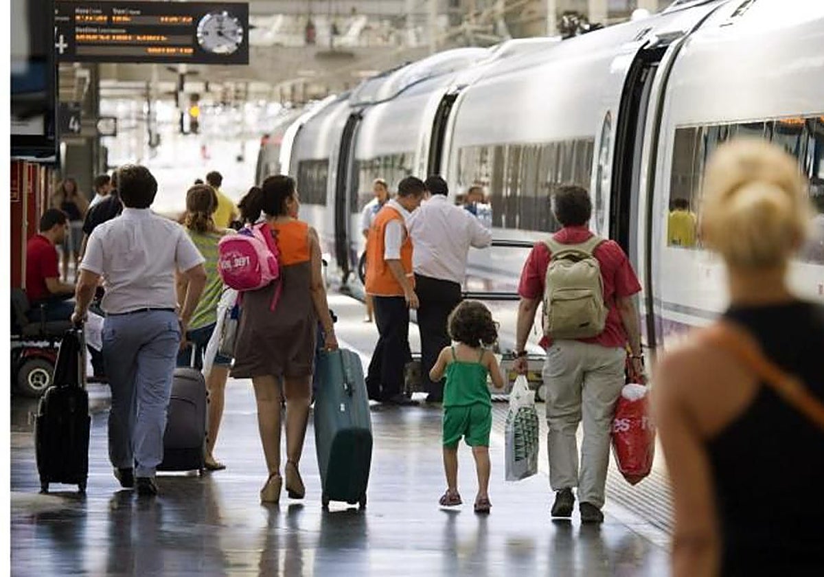 Una familia se dispone a coger un tren en una estación ferroviaria