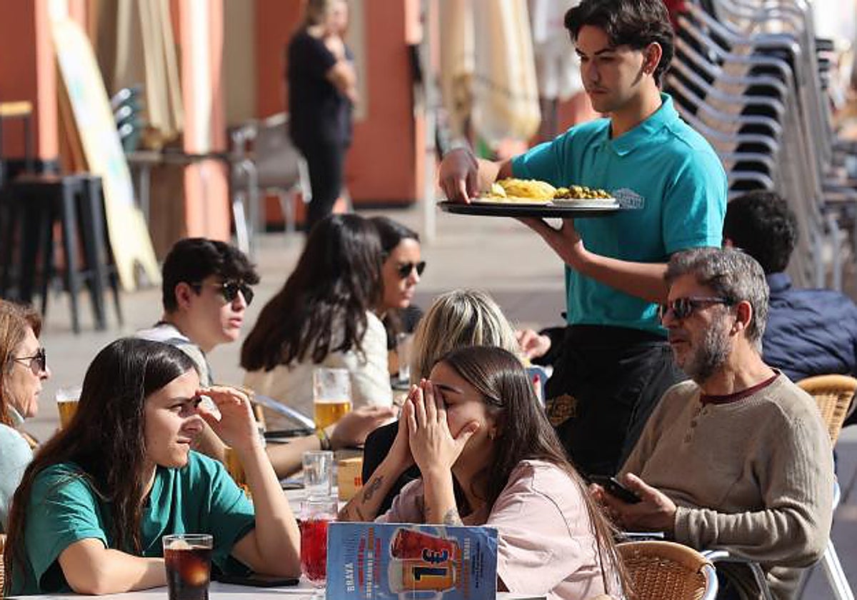 Un joven camarero atiende mesas en una plaza de Córdoba