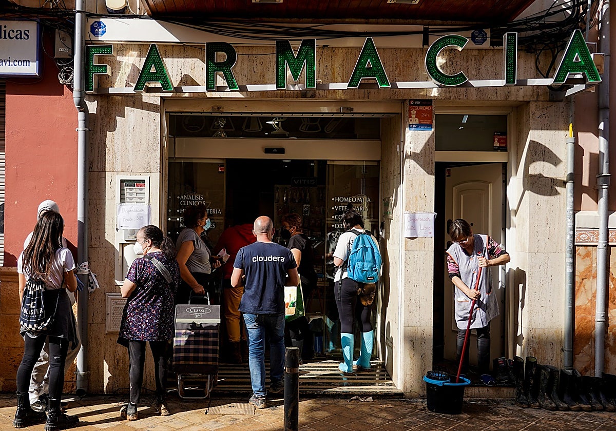 Varias personas hacen cola en un farmacia en Sedavi (Valencia)