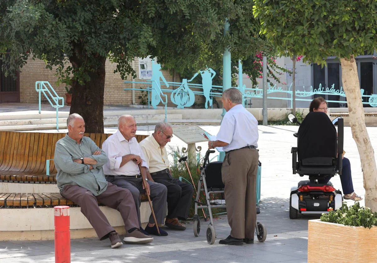 Varios jubilados descansan en un banco en Córdoba