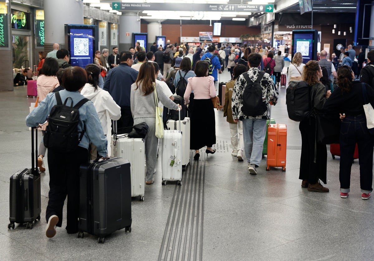 Varios pasajeros esperan su tren en Atocha