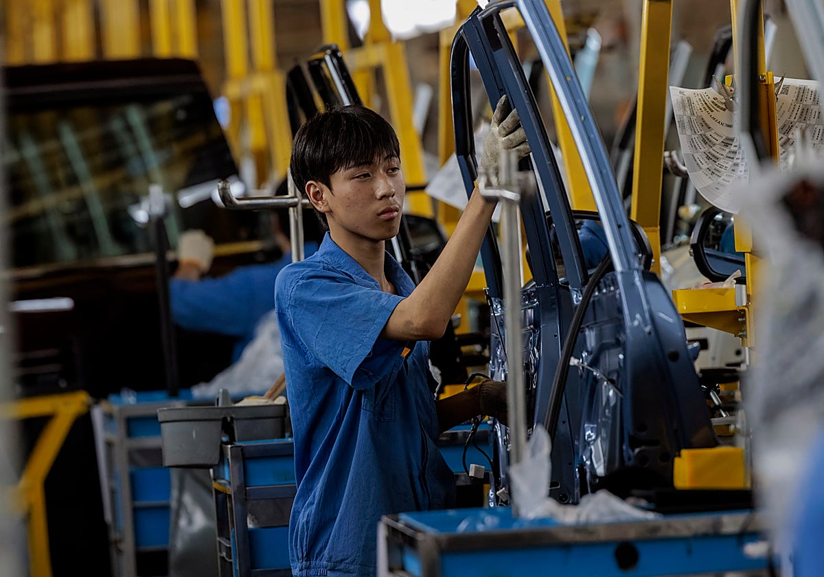 Un empleado trabaja en la línea de ensamblaje de una fábrica de automóviles en Nanjing