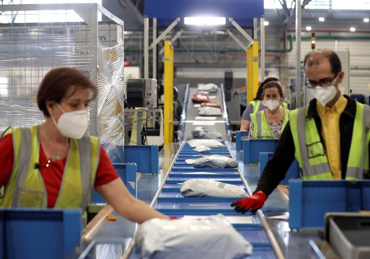 Trabajadores de Correos en una planta de clasificación de envíos