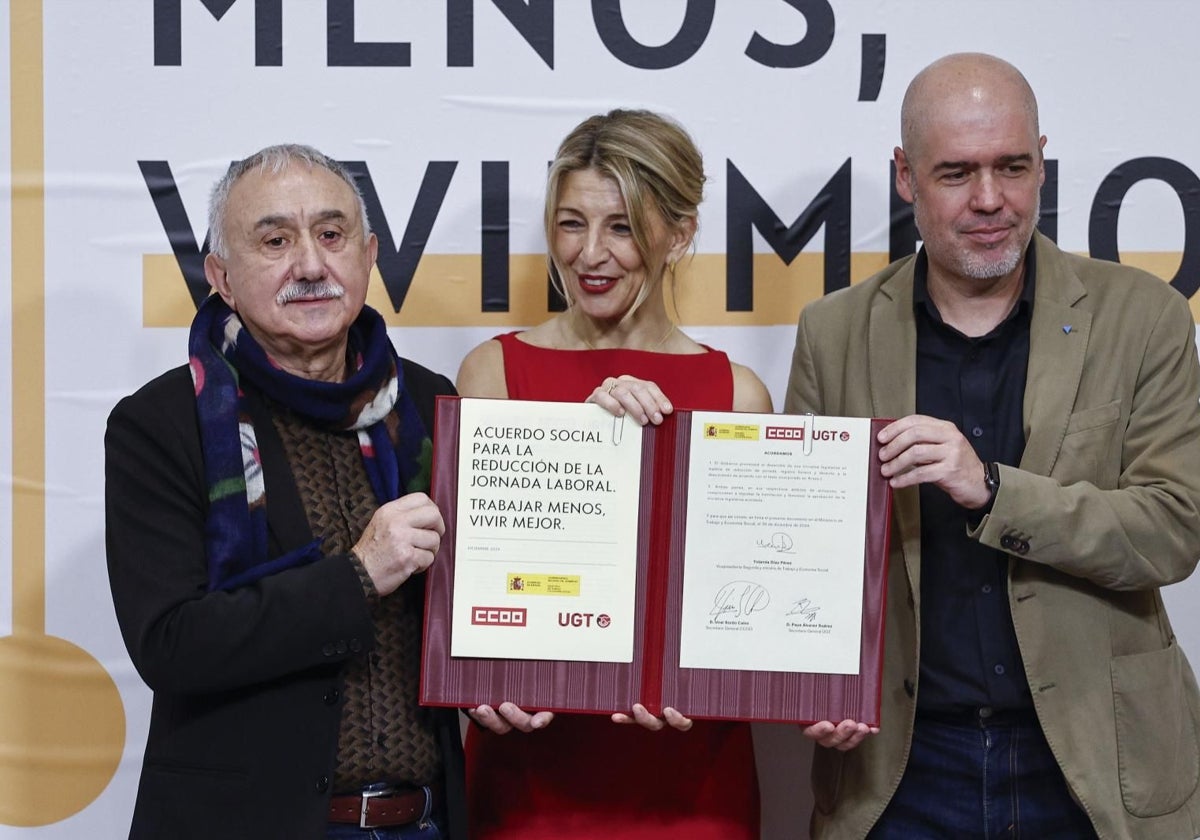 La ministra de Trabajo, Yolanda Díaz, con los líderes de UGT y CC.OO., en diciembre al firmar la ley de jornada laboral.