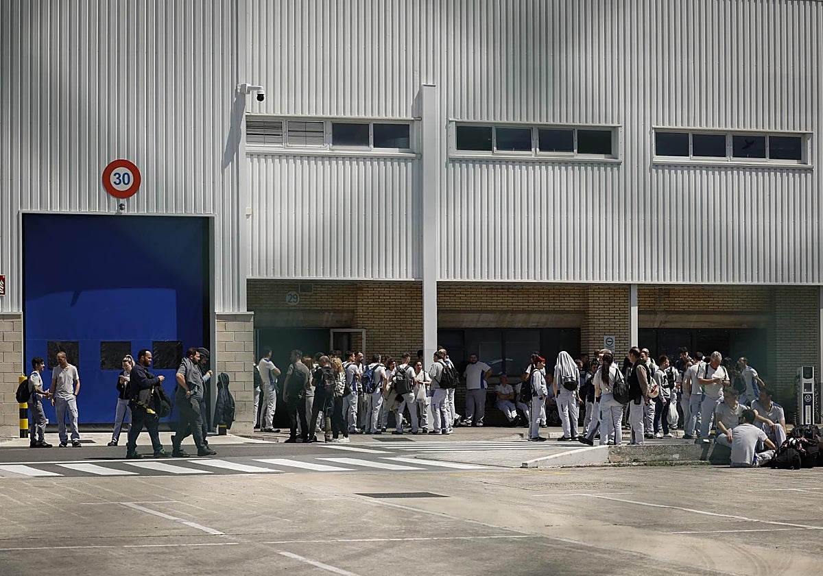 Un grupo de trabajadores esperan en las inmediaciones de una fábrica en Navarra