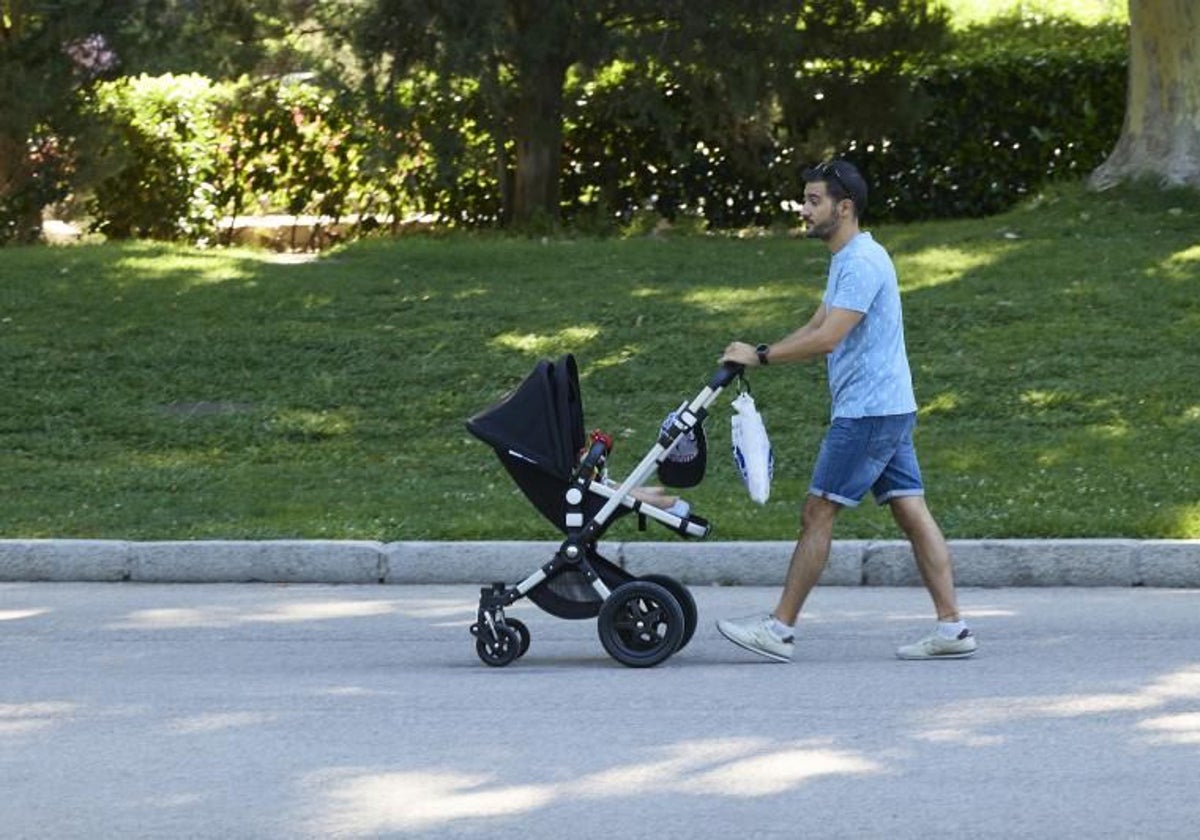 Un joven pasea con un carrito por el parque de El Retiro