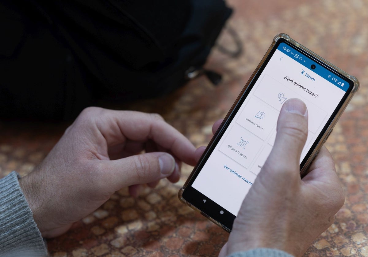 Un hombre utiliza la aplicación de Bizum para hacer un envío de dinero