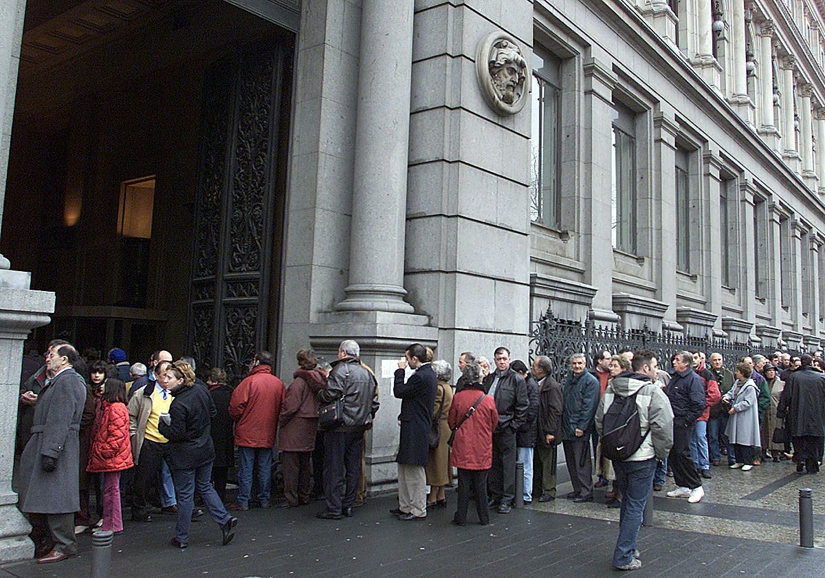 Largas colas en las oficinas del Banco de España en Madrid para cambiar pesetas por euros, en el primer día de puesta en circulación de la nueva moneda