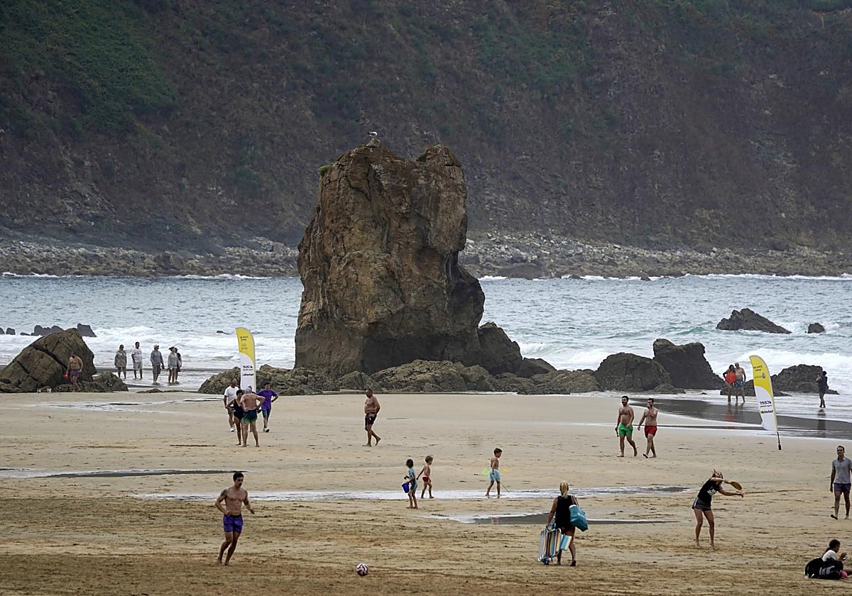 Bañistas a orilla de la playa de El Aguilar en Muros de Nalón (Asturias)