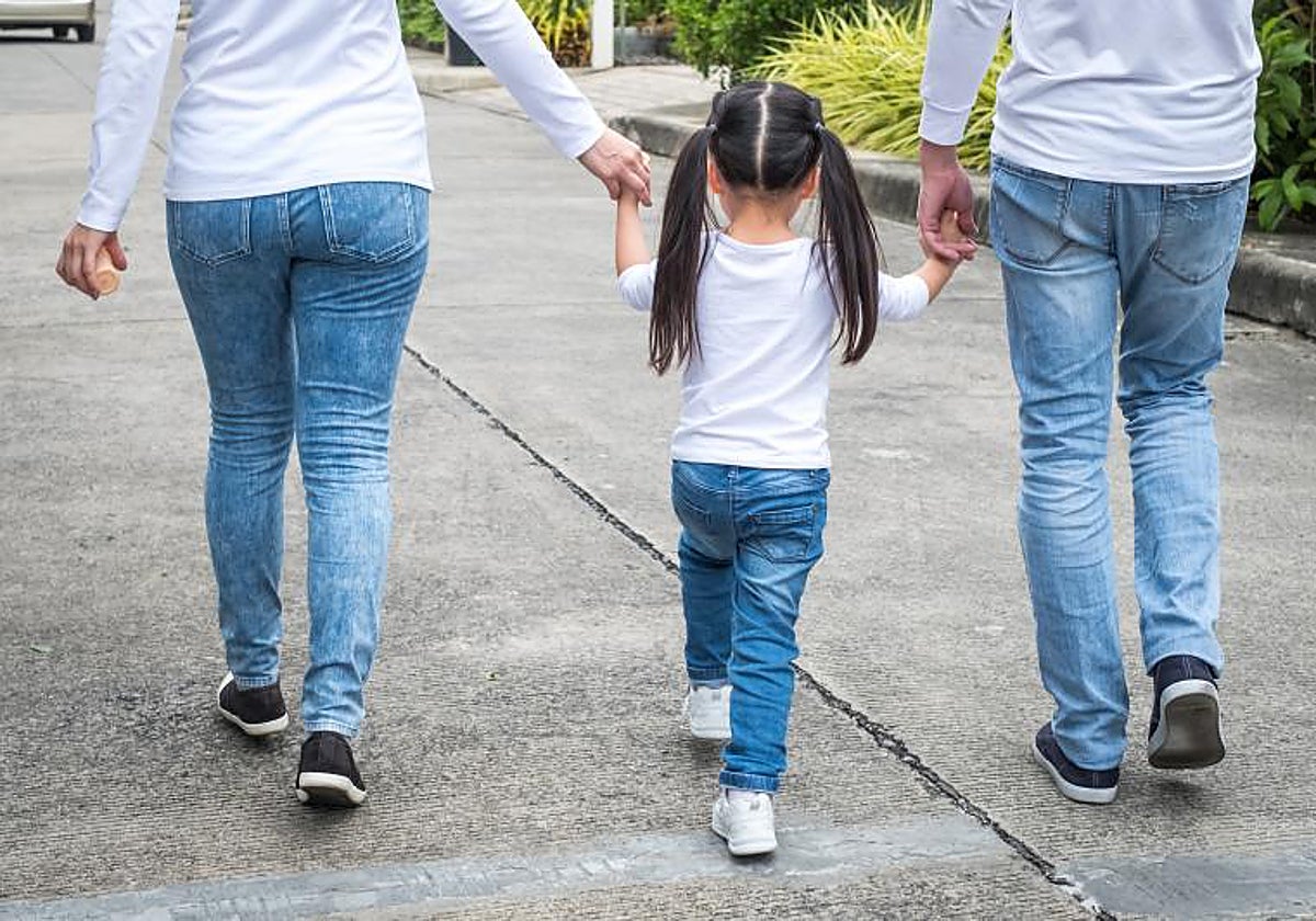Unos padres paseando a su hija