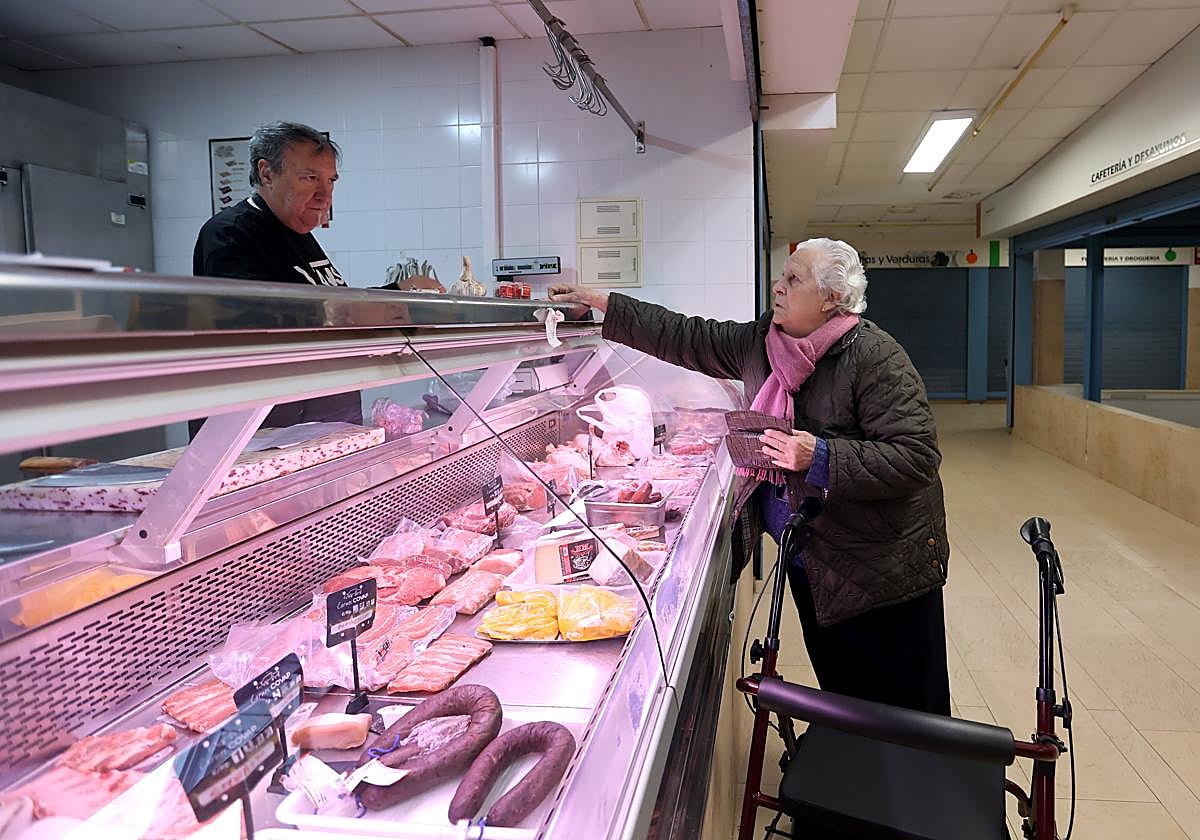 Una mujer compra en una carnicería de un mercado de Córdoba.