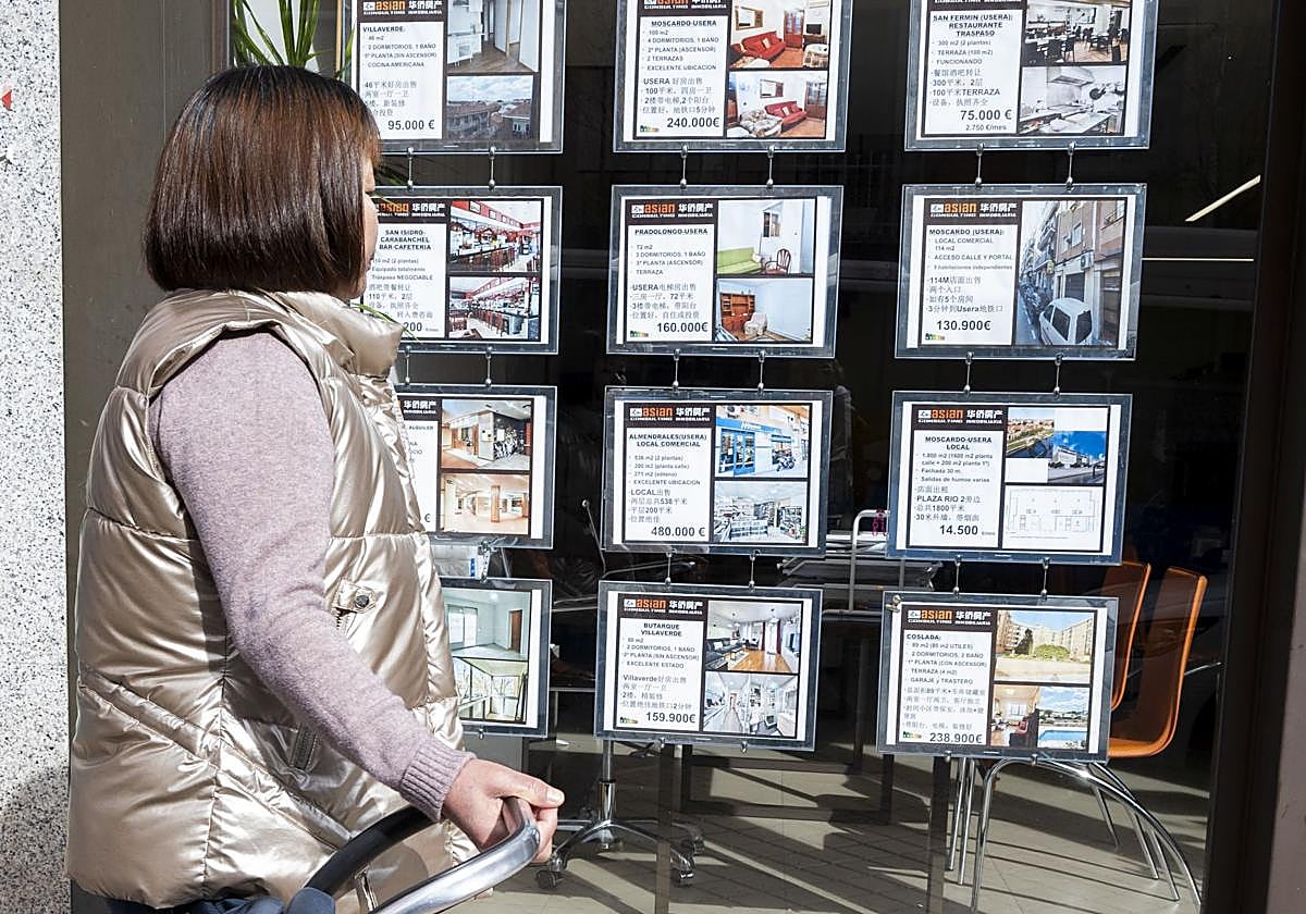 Una viandante consulta los precios de las viviendas de una consultora inmobiliaria