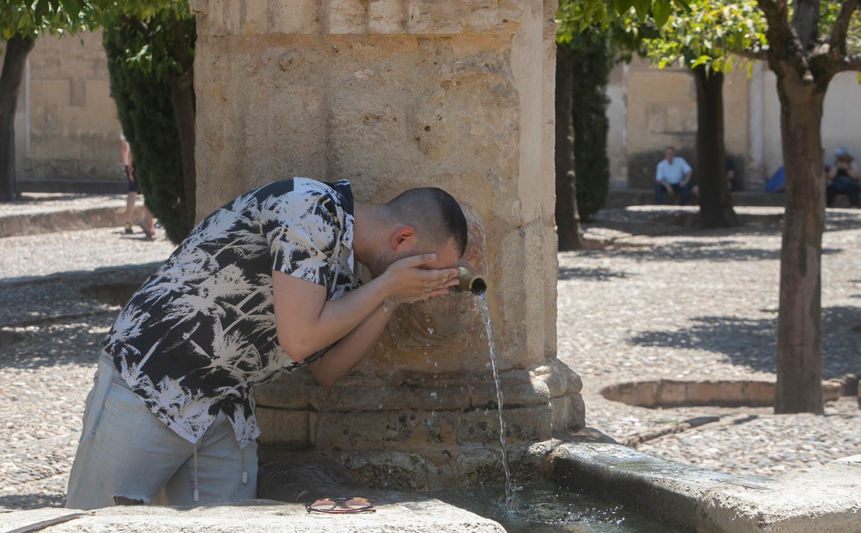 Un joven se moja la cara para refrescarse del calor extremo en Córdoba