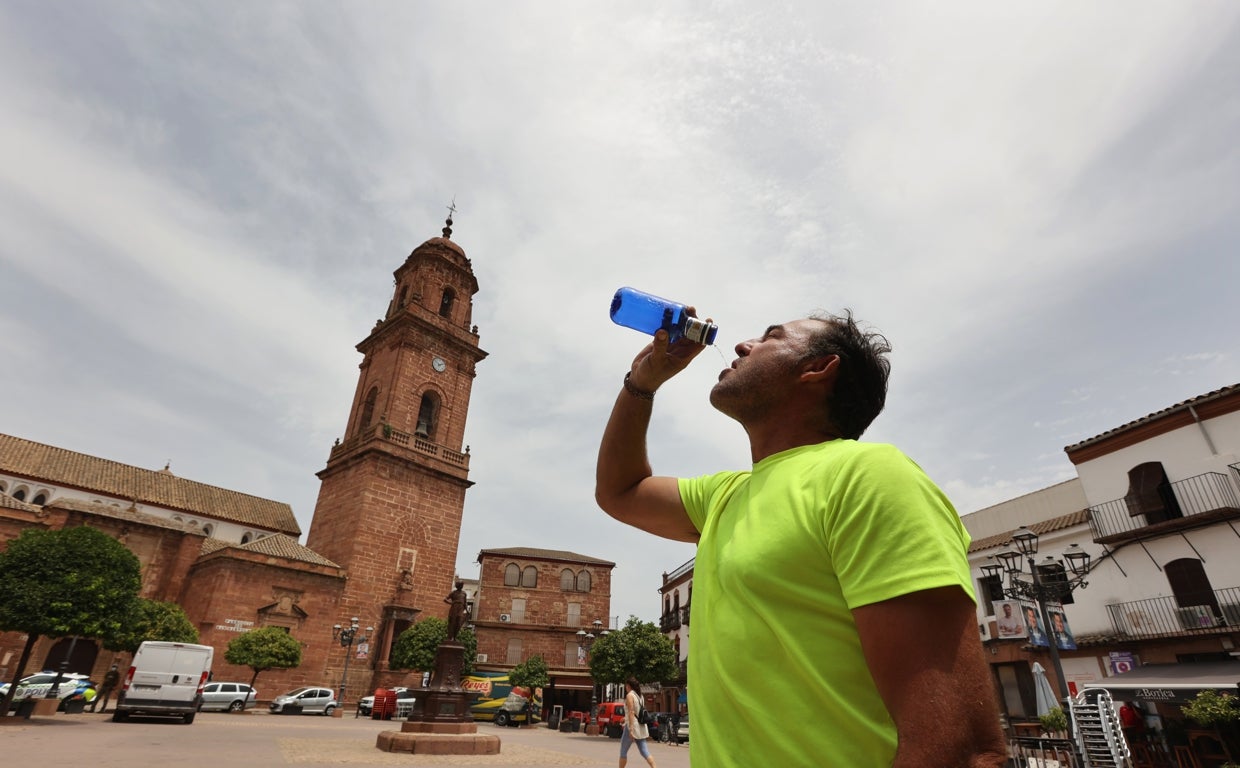 Un montoreño bebe agua, con las vistas del municipio al fondo