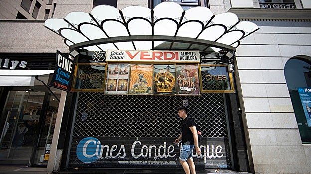 Un chico pasa delante de los cines Conde Duque de Alberto Aguilera