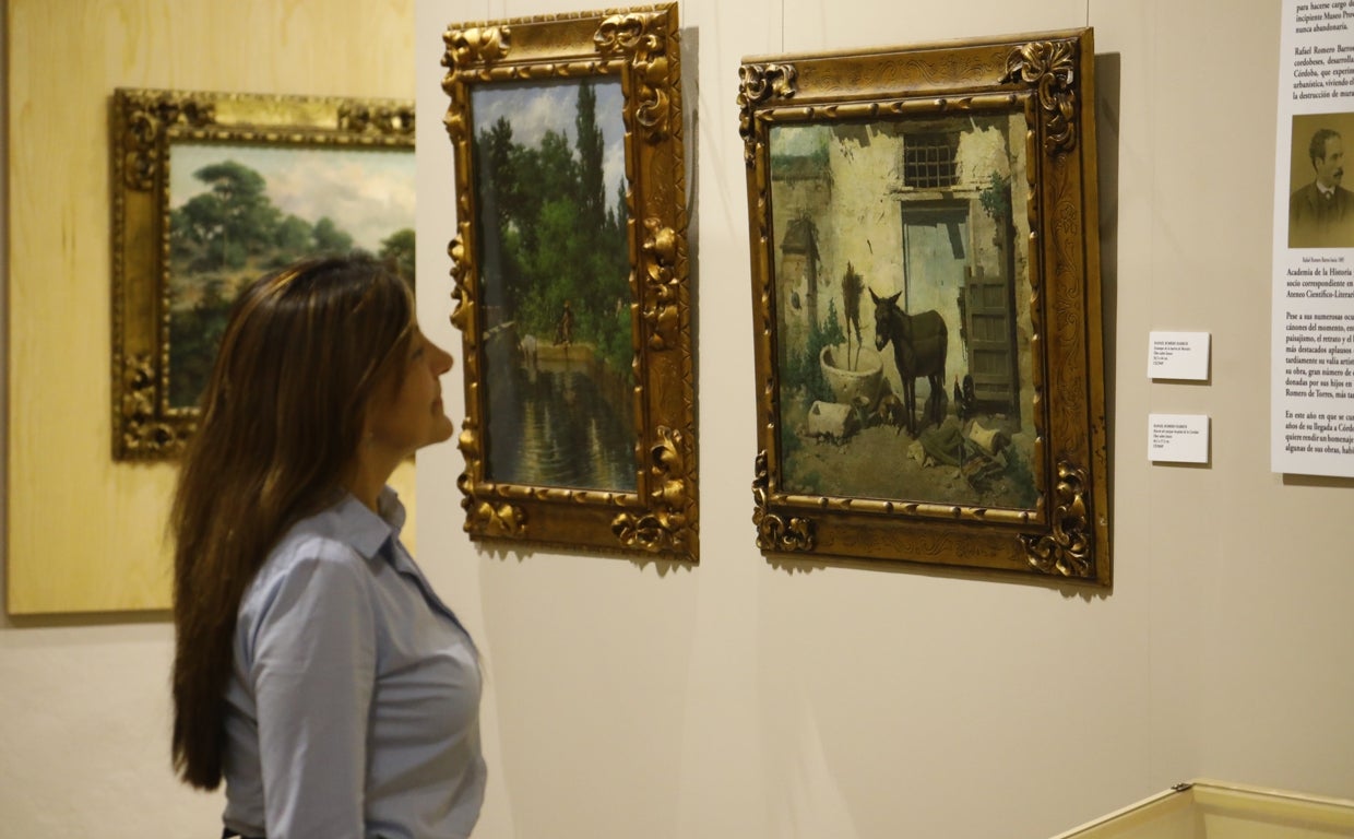 Una mujer observa dos obras de la exposición