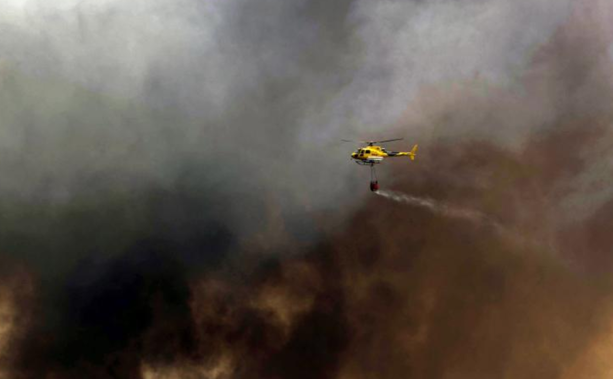 Helicóptero actuando contra el fuego que afecta ya a tres municipios con un perímetro de 11 kilómetros