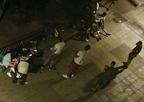 Imagen secundaria 1 - Restos de botellón (arriba) esta semana, en una de las plazas donde se reúnen los vecinos. Una papelera destrozada y, abajo a la izquierda, una docena de jóvenes en pleno botellón, de madrugada