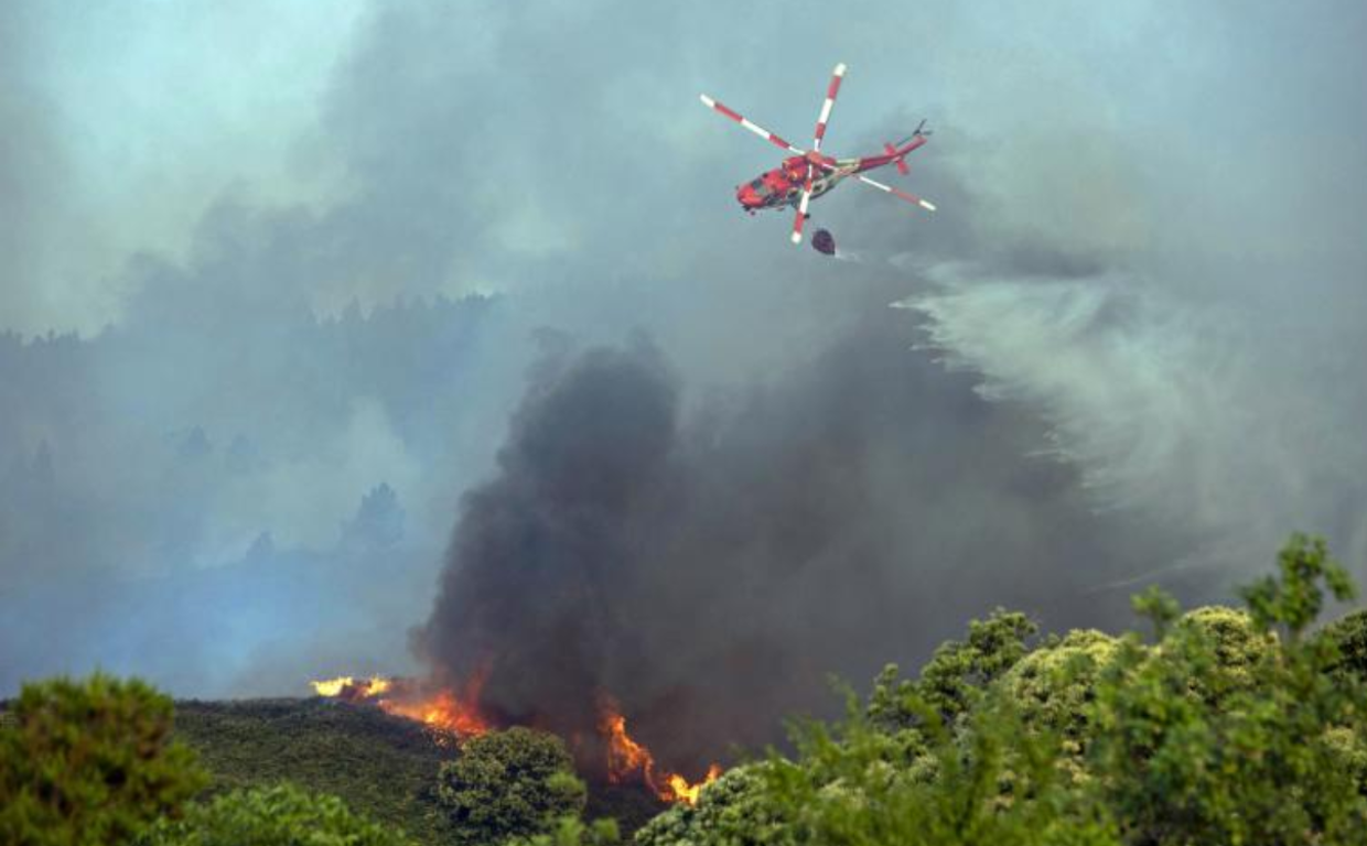 Un helicóptero descarga sobre las llamas en el incendio de Los Realejos
