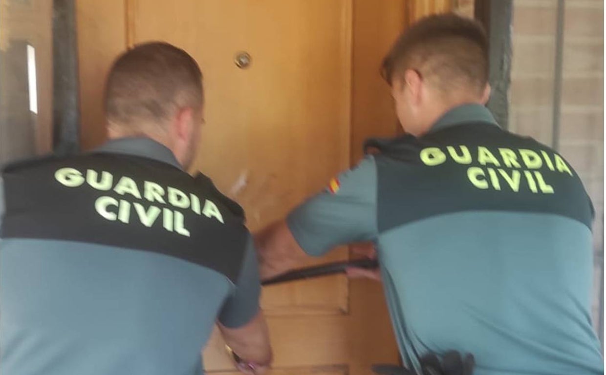 Dos agentes de la Guardia Civil en el momento de forzar la puerta para socorrer al anciano inconsciente