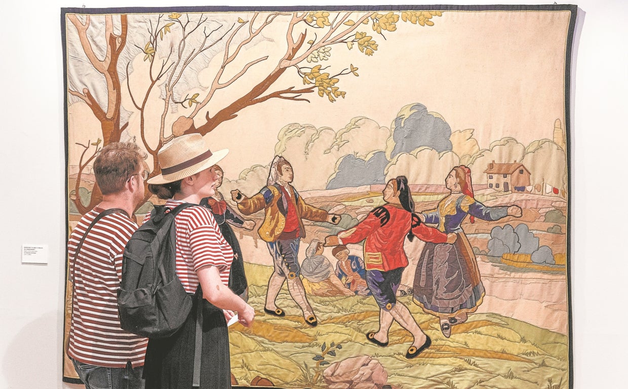 Dos paseantes admiran uno de los tapices