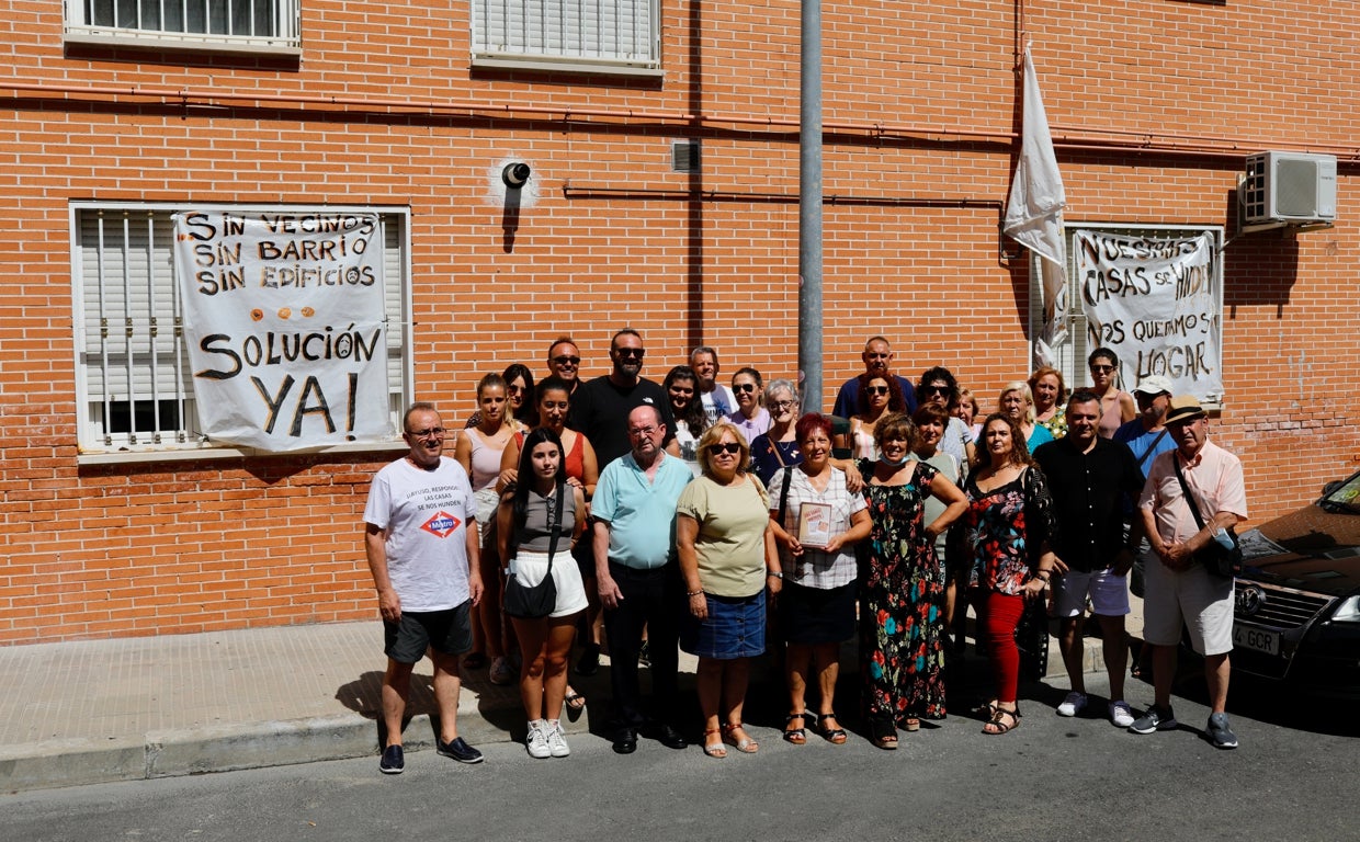 Una treintena de afectados, en las calles dañadas por la obra de Metro, junto a las pancartas que piden soluciones