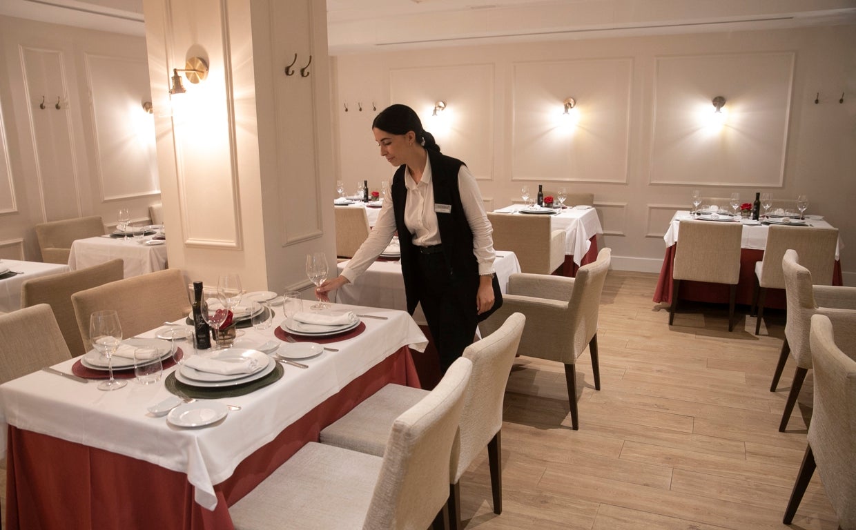 Una trabajadora prepara las mesas en un restaurante de Córdoba