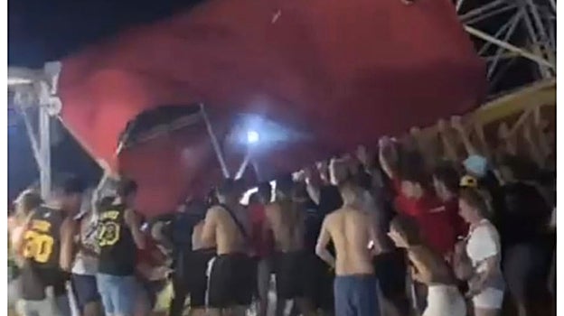 Espectadores del Medusa Festival sostienen una parte del escenario que se viene abajo