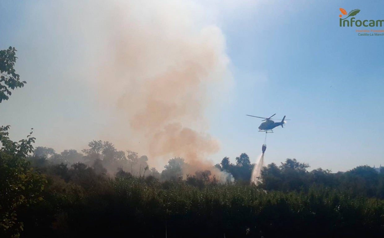 El helicóptero descarga agua recogida del Tajo sobre el incendio