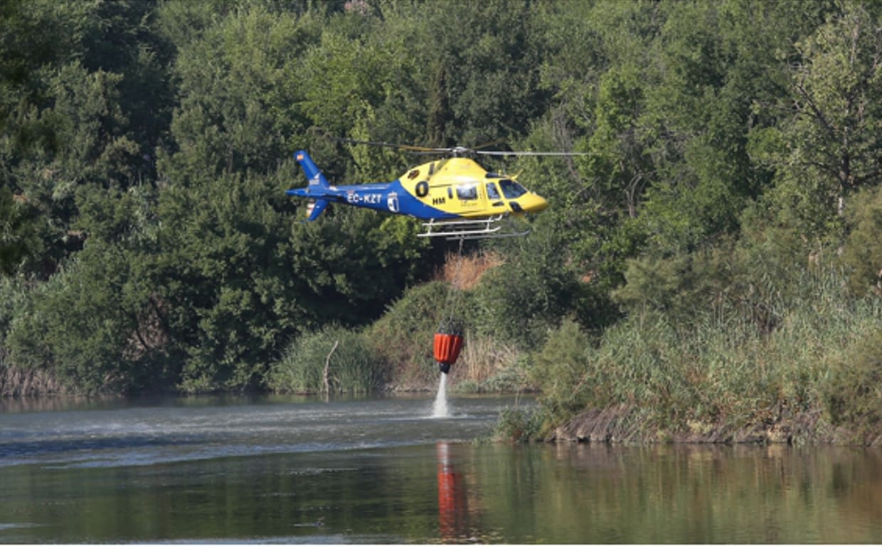 Un helicóptero del Infocam carga agua del Tajo