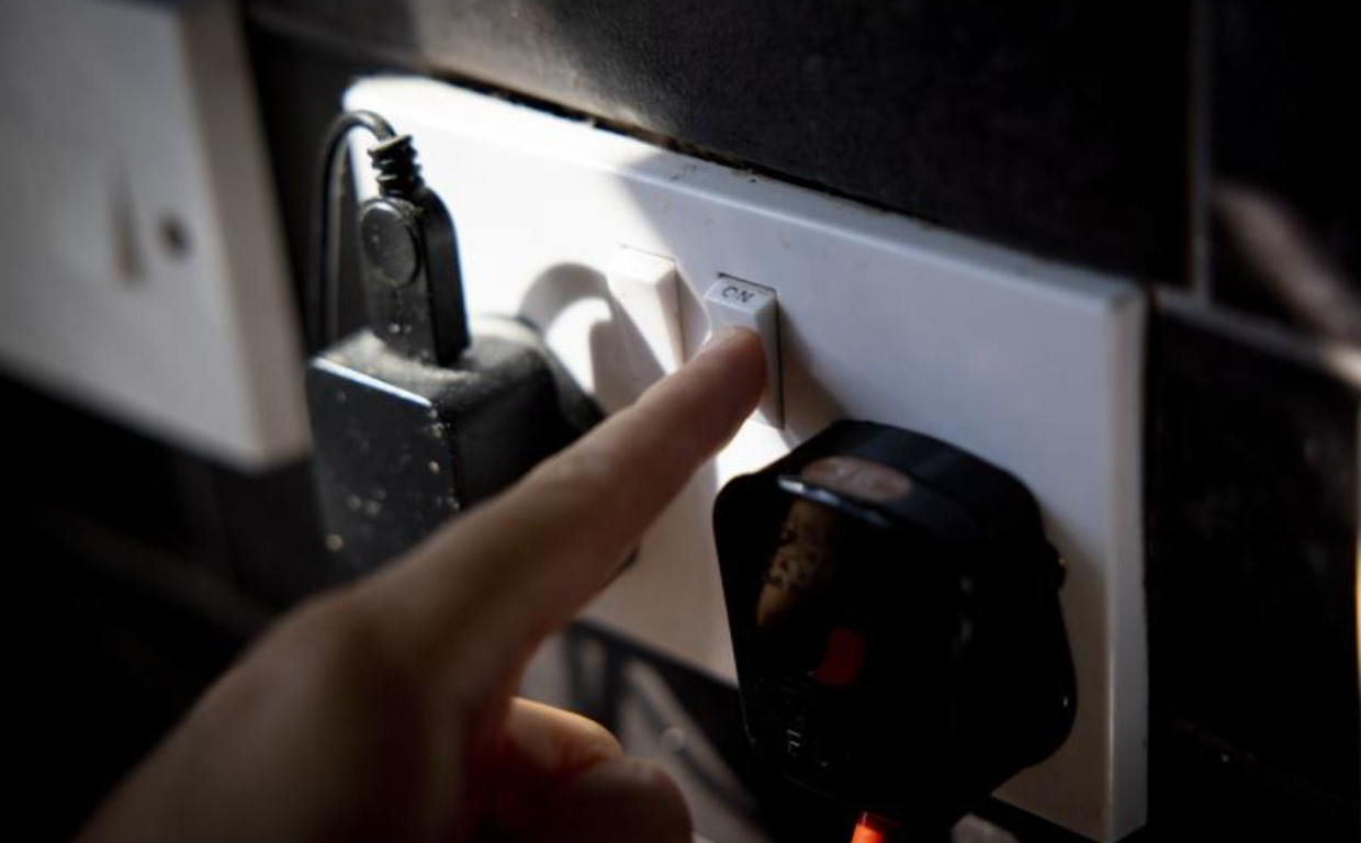 Un usuario apaga la conexión en un enchufe en foto de archivo