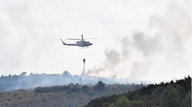 Un helicóptero descarga en el incendio declarado este sábado por un rayo en Les Useres (Castellón)