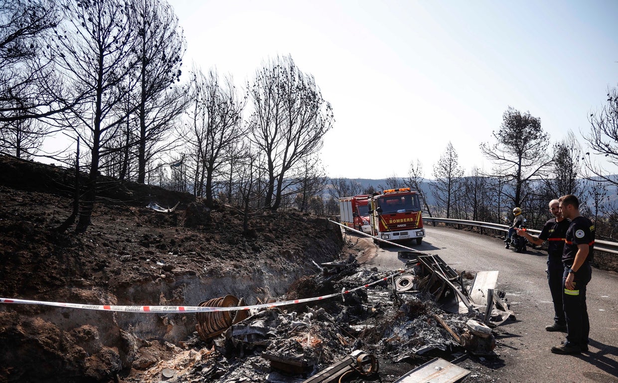 Imagen de los bomberos junto a los restos calcinados de su camión por el incendio de Bejís (Castellón)