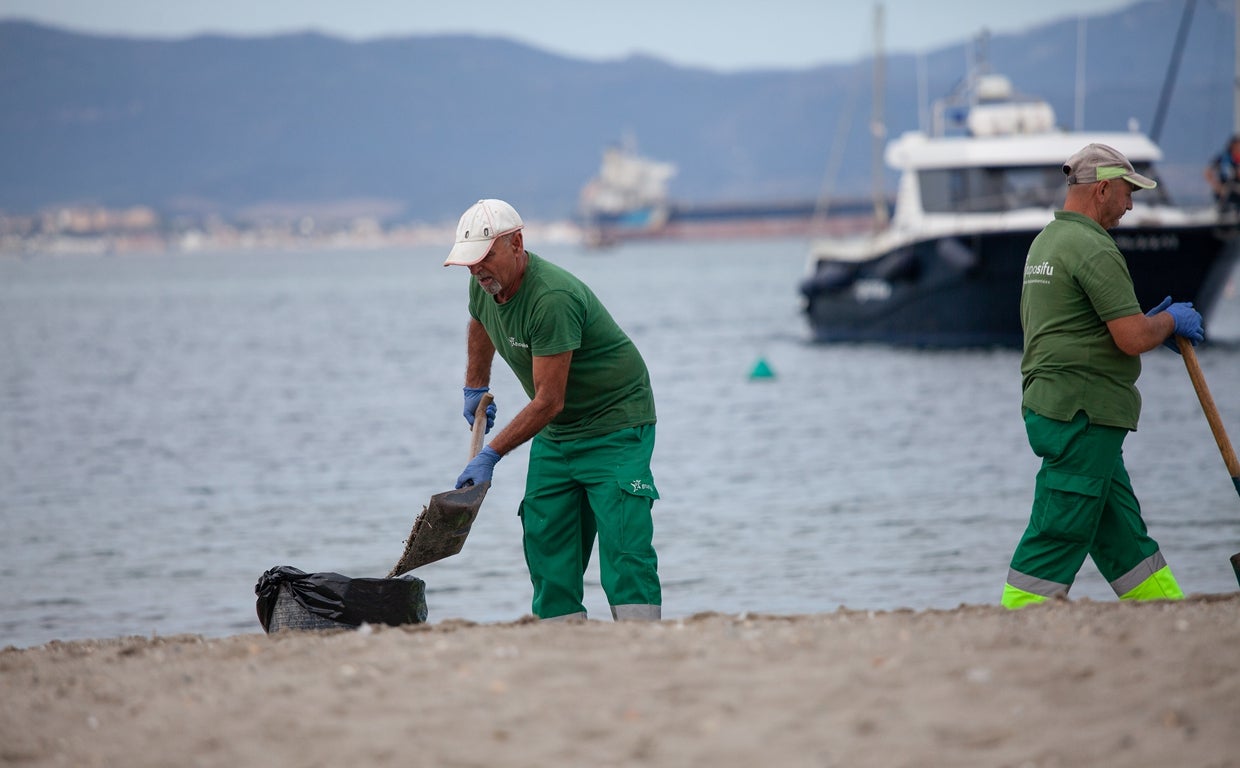 Operarios municipales retiran el vertido de la playa de La Línea