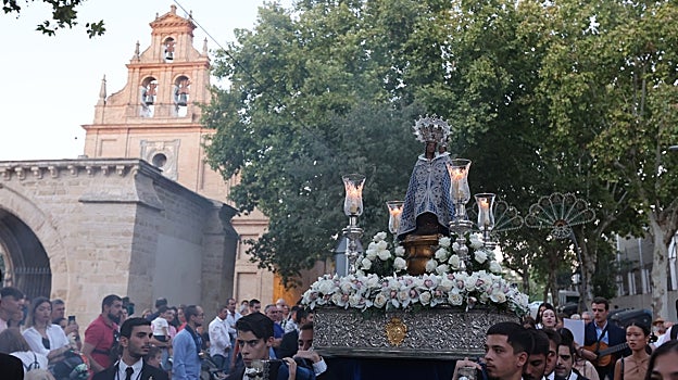 La Virgen, llevada a hombros por jóvenes, con el santuario al fondo