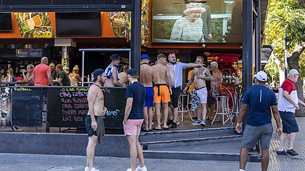 Imágenes de la monarca en televisión en un bar frecuentado por británicos