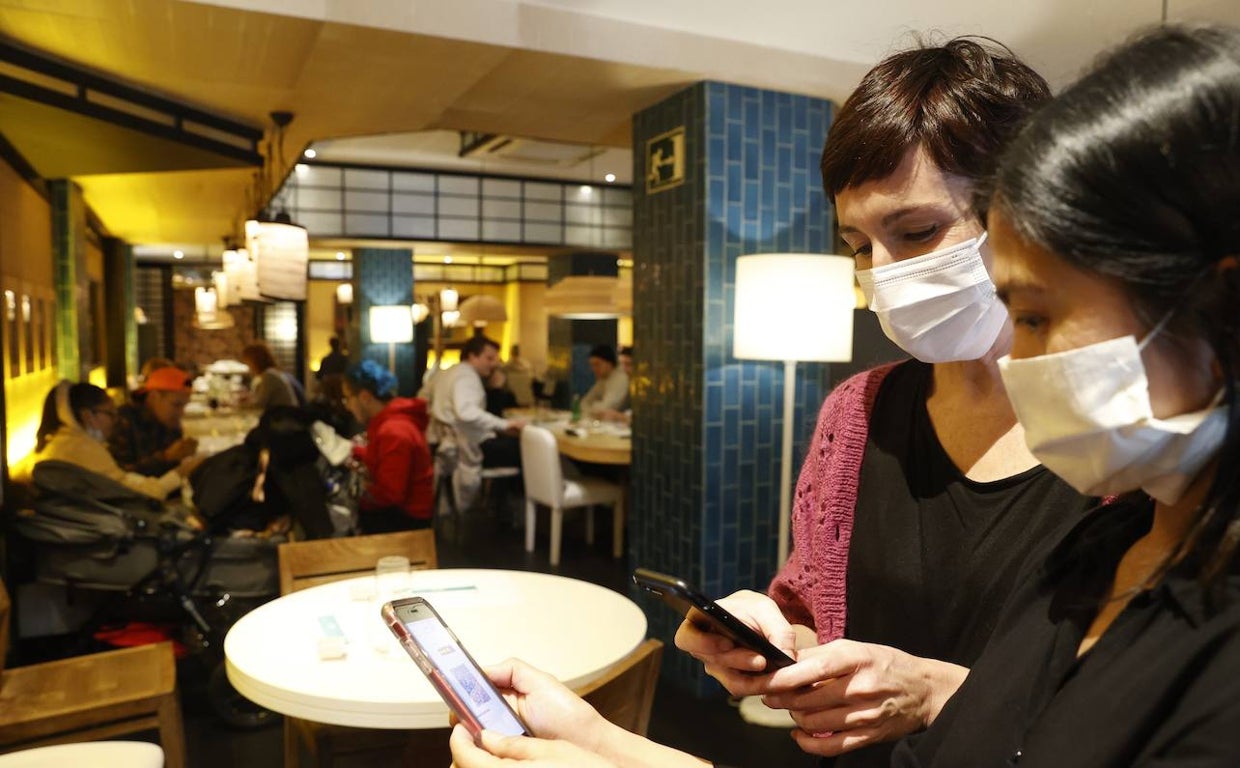 Una mujer enseña el pasaporte covid para acceder a un restaurante de Bilbao