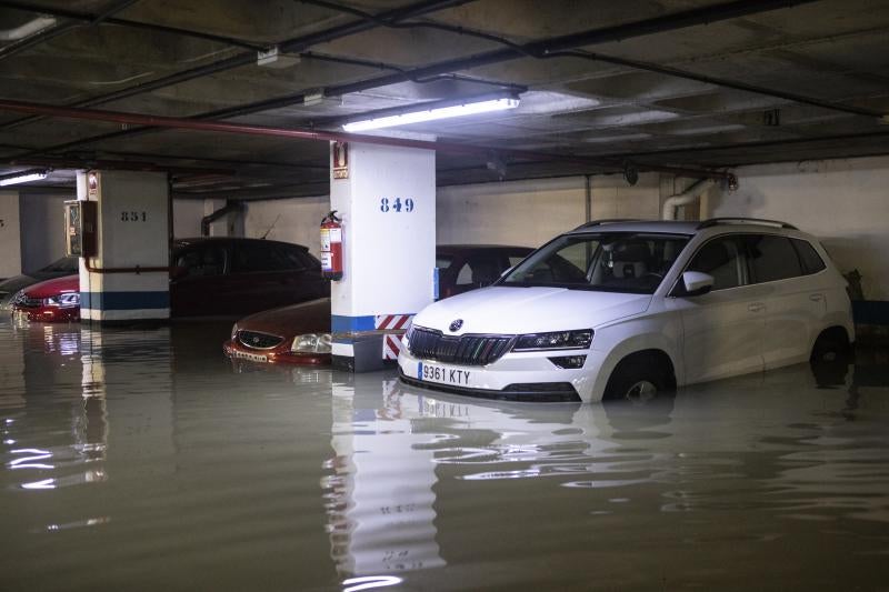 Varios vehículos  aparcados en un garaje inundado en la calle Antonio López