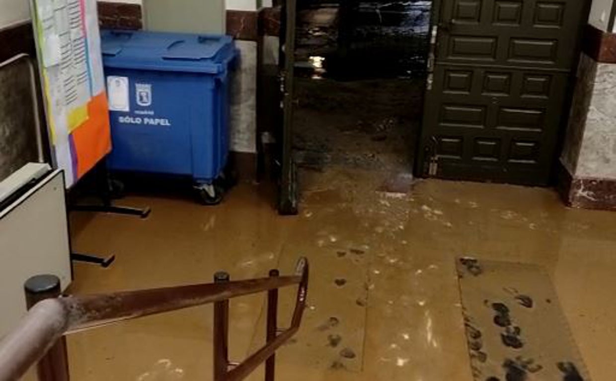 La entrada al colegio público Concepción Arenal anegada de agua y barro tras la rotura de la tubería