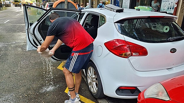 Javier achica el agua de su vehículo con una pequeña toalla