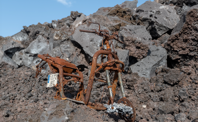 Imagen principal - Antes de la erupción, una moto, una casa y libros, convertidos en un amasijo tras el paso de la lava