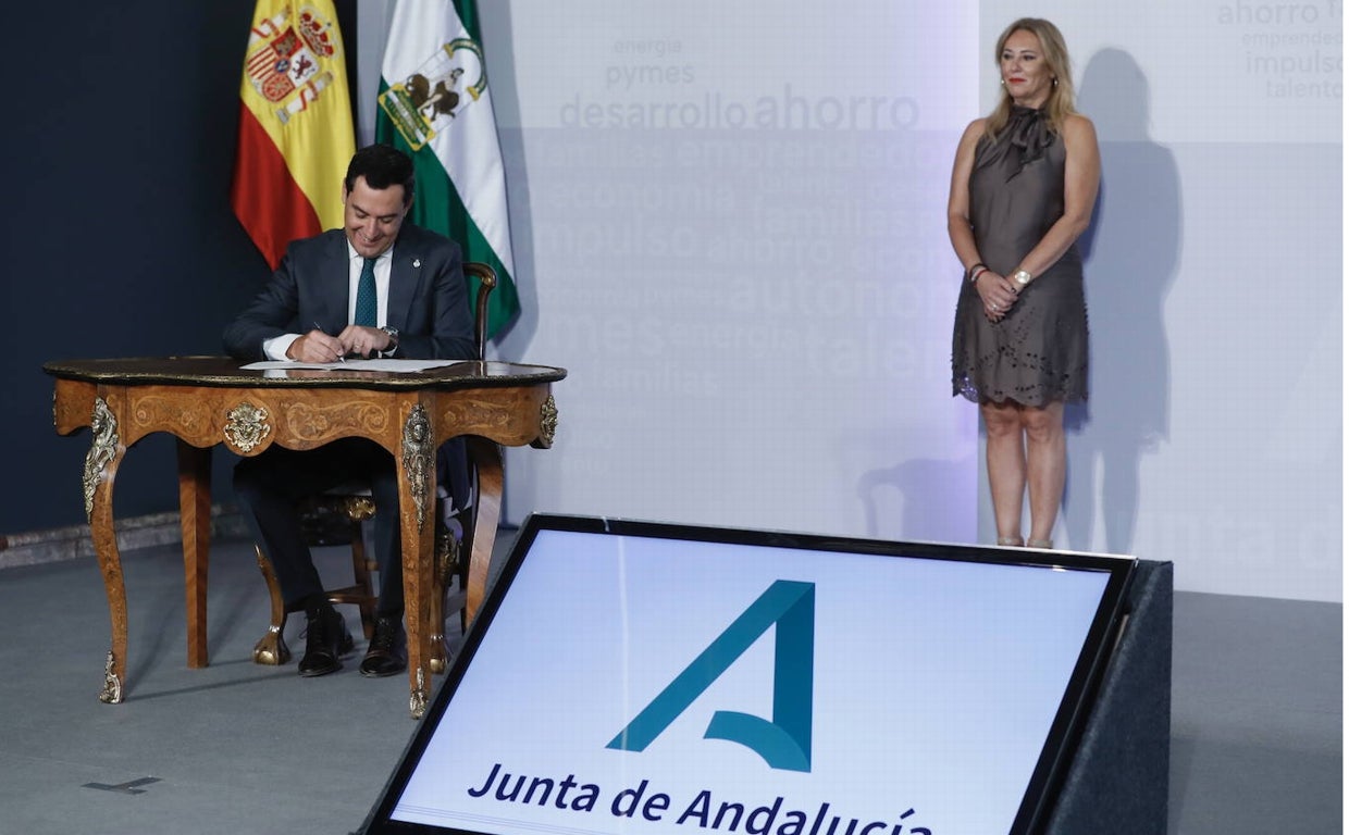 El presidente de la Junta de Andalucía, Juanma Moreno, junto a la consejería de Economía y Hacienda, Carolina España, en el acto institucional de firma del decreto ley de bajada de impuestos frente a la inflación