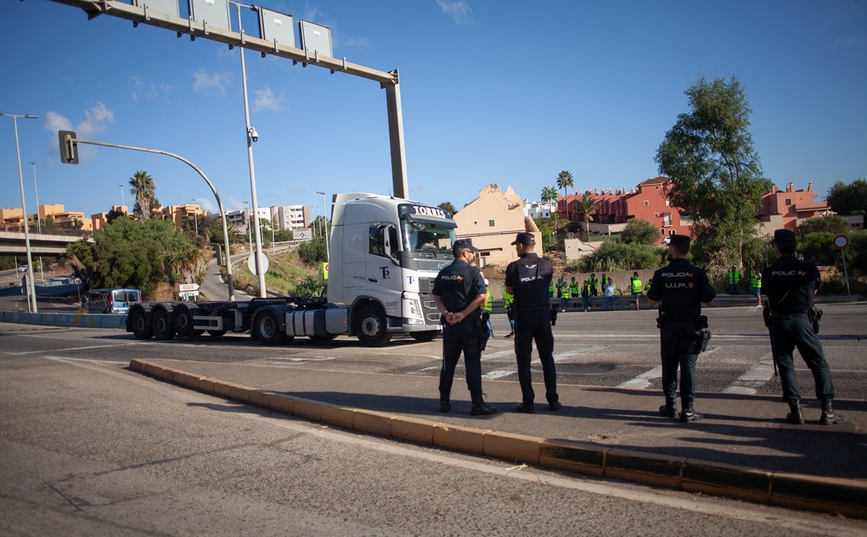 Policías nacionales garantizan el acceso al puerto con miembros del piquete al fondo de la imagen