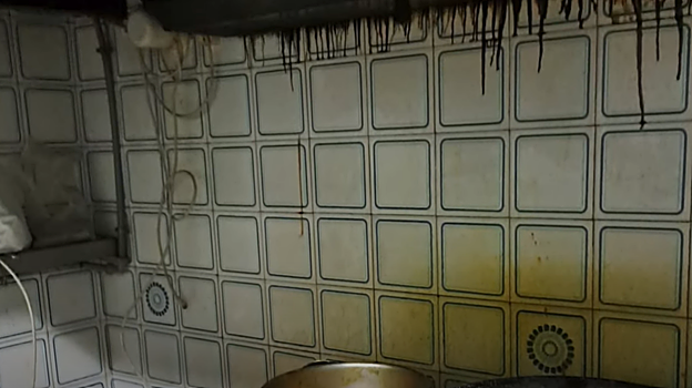 Chorros de grasa del extractor de humos roto sobre los fogones de la cocina.