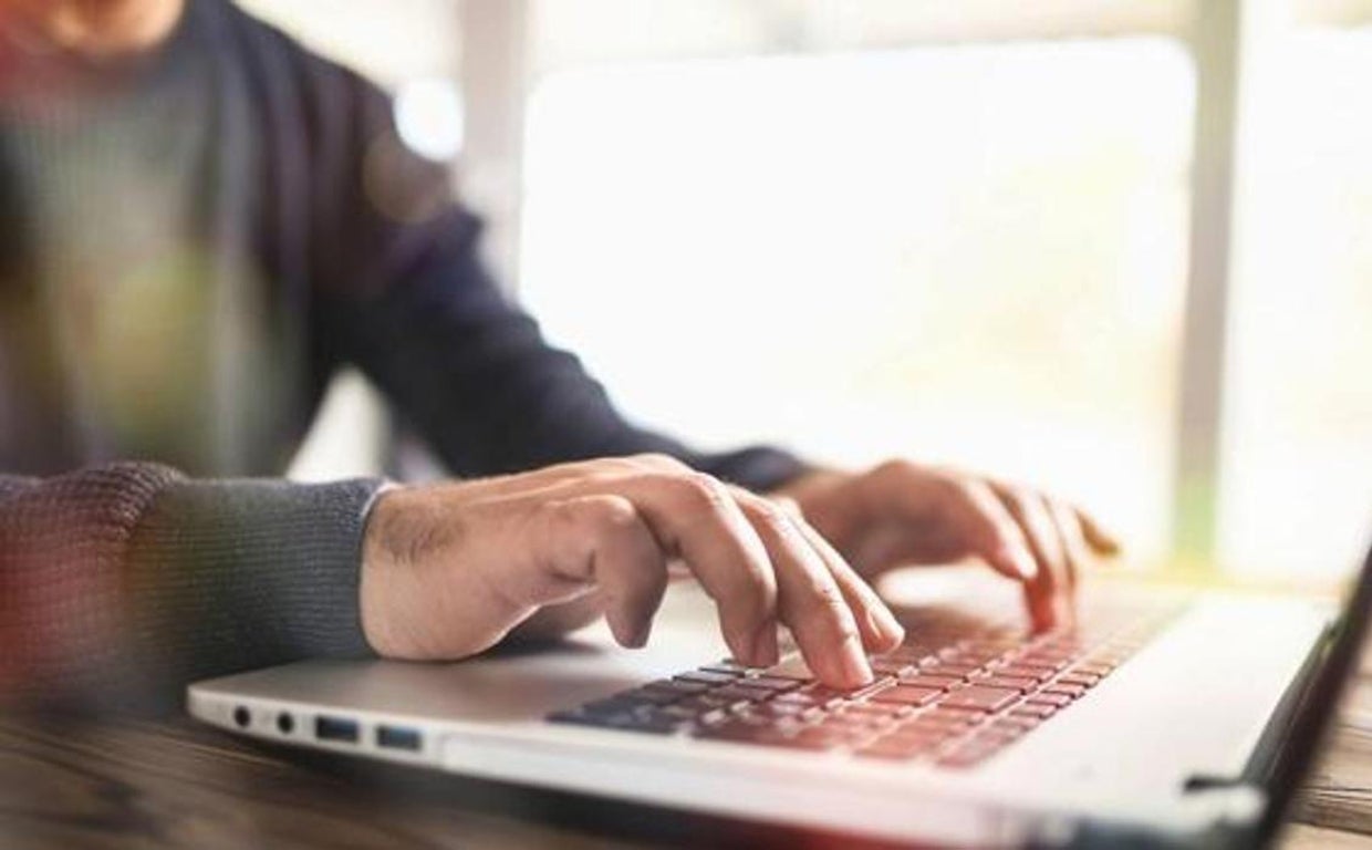 Fotografía de archivo de un hombre tecleando en un portátil