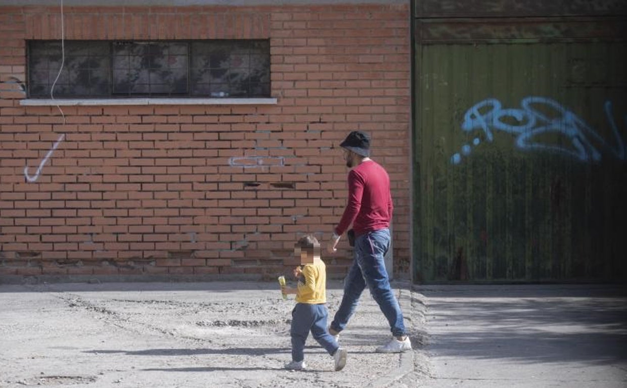 Un okupa se dirige a una de las naves junto a un niño pequeño