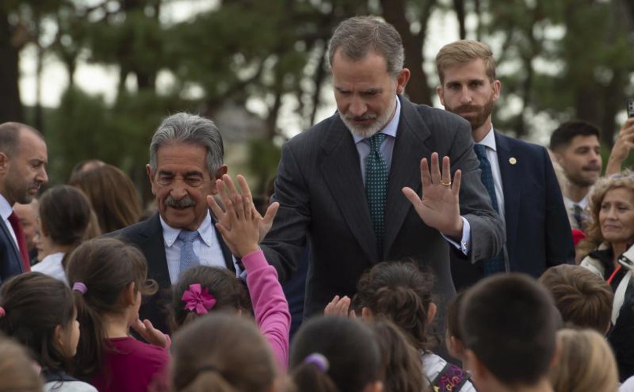 El Rey saluda a unos niños, junto al presidente cántabro, Miguel Ángel Revilla, a la entrada del Palacio de la Magdalena, en Santander