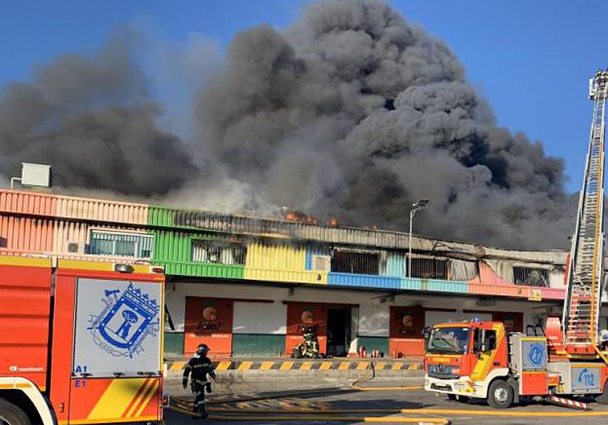 Los bomberos del ayuntamiento trabajan en la extinción de la nave afectada en Mercamadrid, que será reconstruida en enero