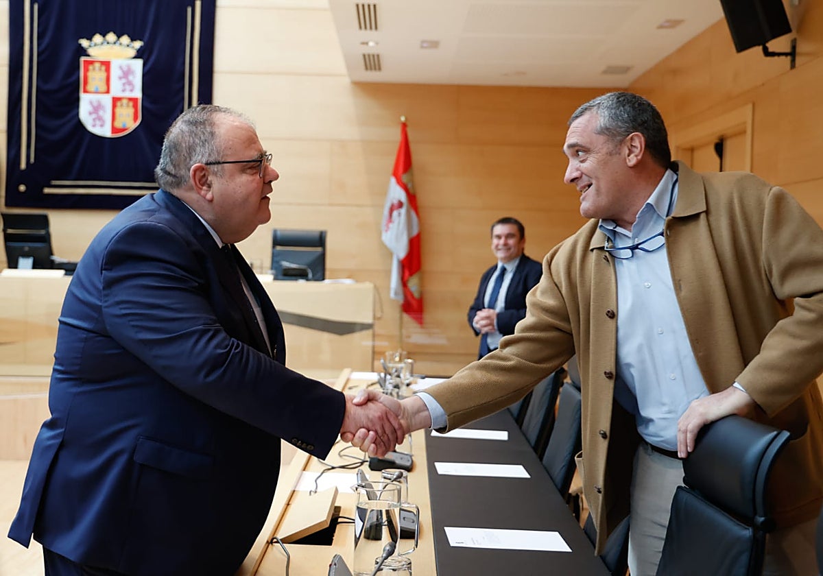 El consejero de Sanidad saluda al procurador de Por Ávila, Pedro Pascual, antes de comparecer en las Cortes